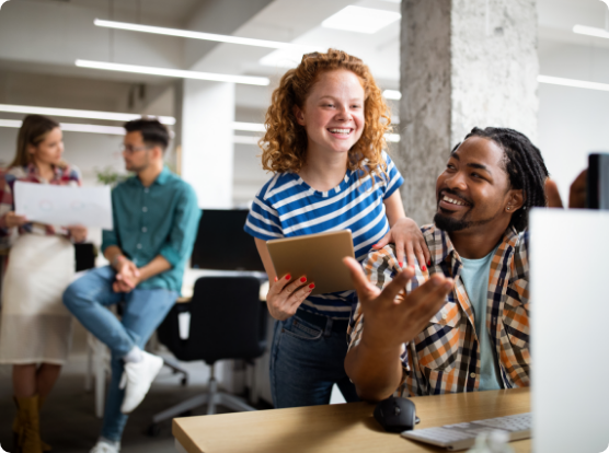 People smiling around a computer